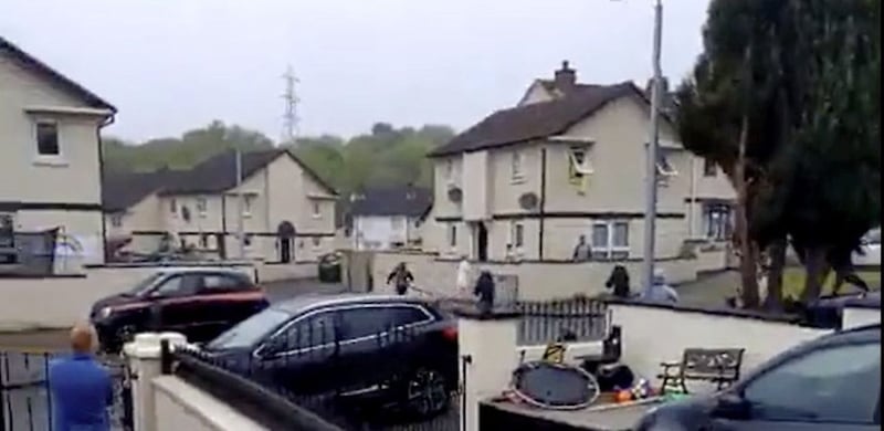 The man carrying a plank of wood makes off with uniform PSNI officers in pursuit. 