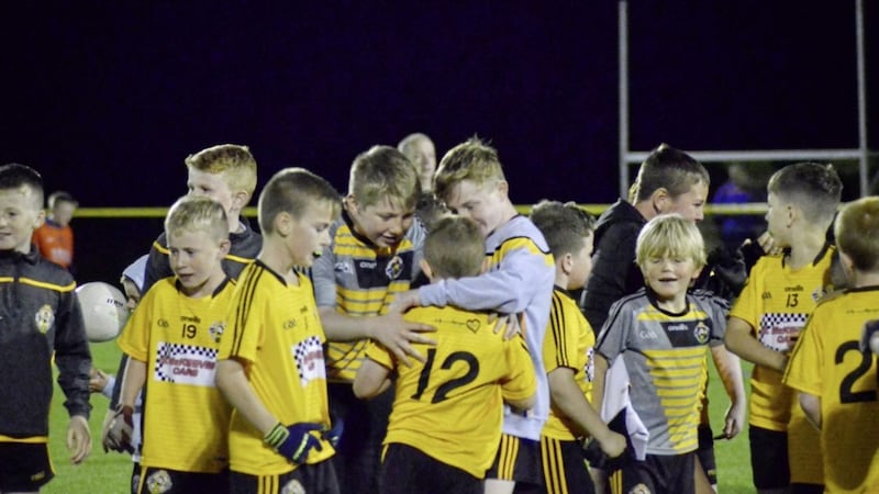 Brothers Conor (number 12) and Ryan McKeever (right in the grey jumper) embrace after the younger sibling captained Portglenone to victory in the U10 cup at an event held in memory of their father, Paul, at the weekend. Picture by Colleen Webb