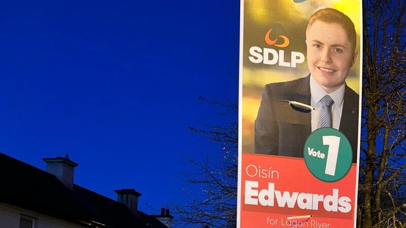 SDLP candidate Oisín Edwards pictured last Thursday with one of his election posters in Waringstown that was later stolen. Picture: Oisín Edwards/Twitter