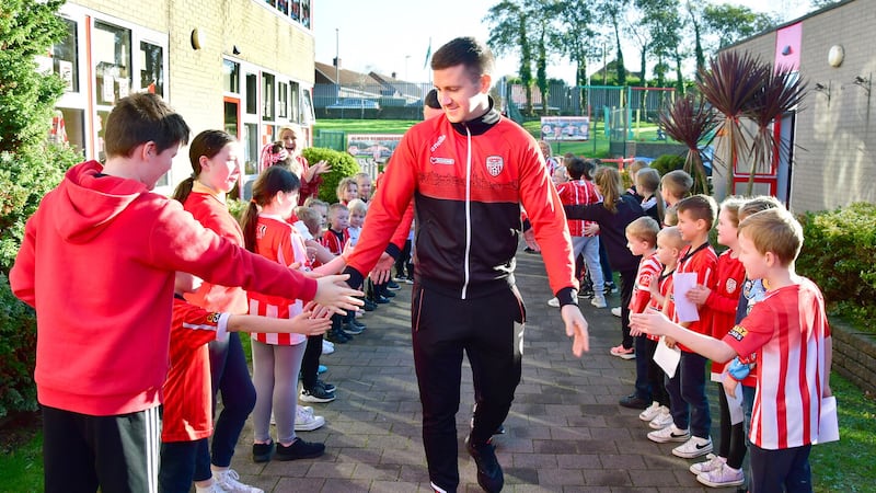 Derry City captain Patrick McEleney makes his way into Steelstown Primary School in Derry to meet young city fans in the build-up to the FAI Cup Final this weekend   Picture: Margaret McLaughlin