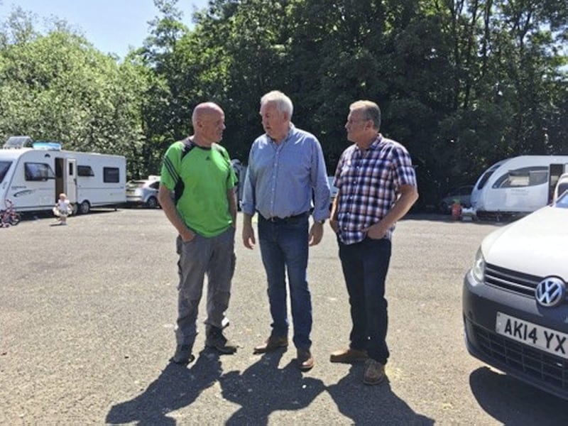 Sinn F&eacute;in councillor Sean McGlinchy in conversation with party colleague Sean McPeake and assembly member Ian Milne at a Traveller camp near Ballyronan on the shores of Lough Neagh 