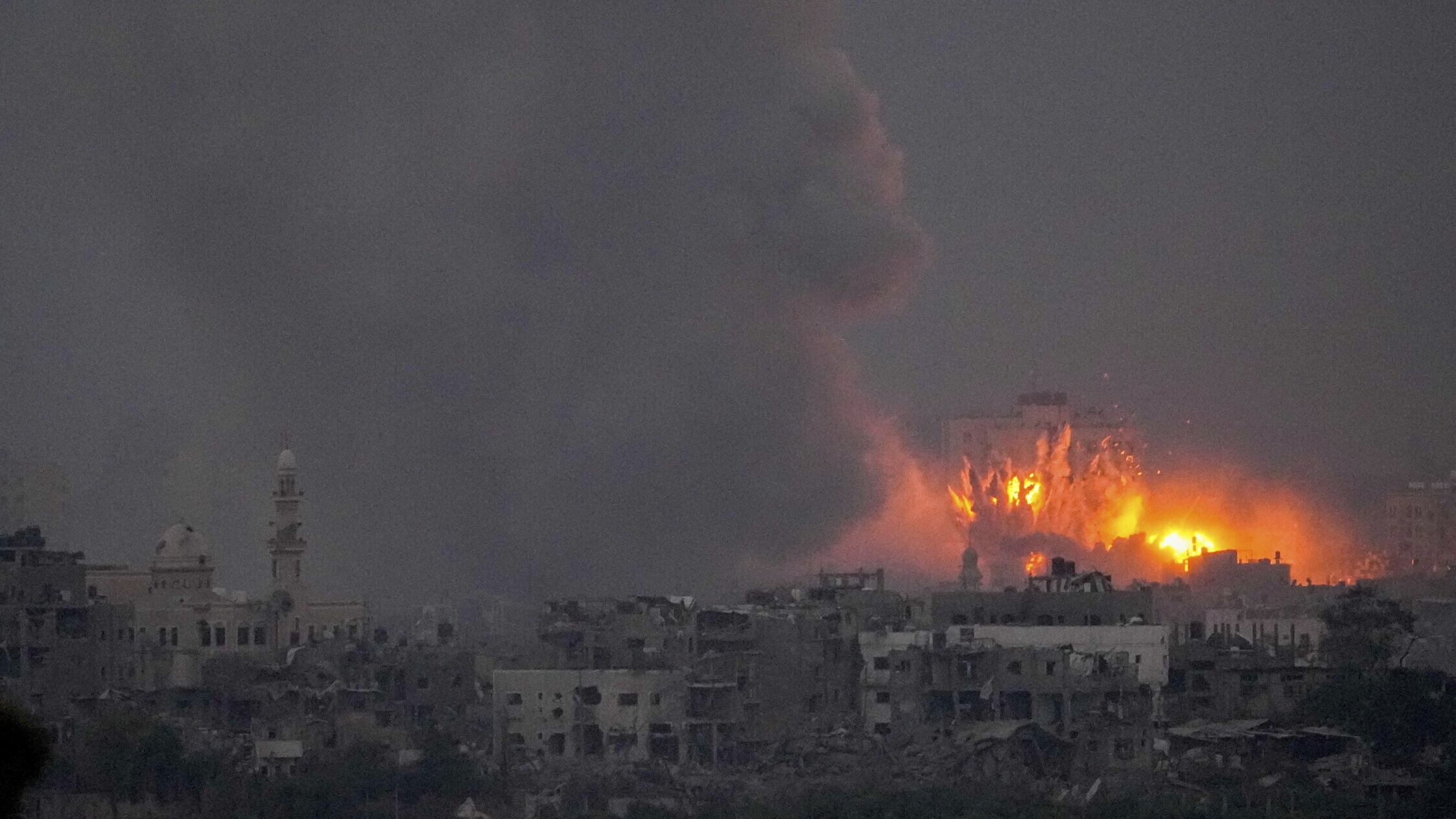 Smoke and fire rise above the Gaza Strip following an Israeli air strike (Ariel Schalit/AP)