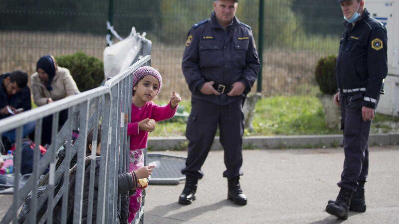 Slovenian policemen guard the registration facility in Petisovci, Slovenia, at the border with Croatia, Sunday, Oct. 18, 2015. Pictures by Darko Bandic/AP
