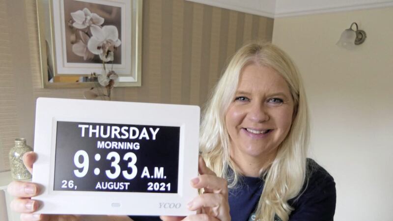 Sinead Hyndman from Clanmil Housing Association with an orientation clock, one of the aids that can be of great help to people with dementia 