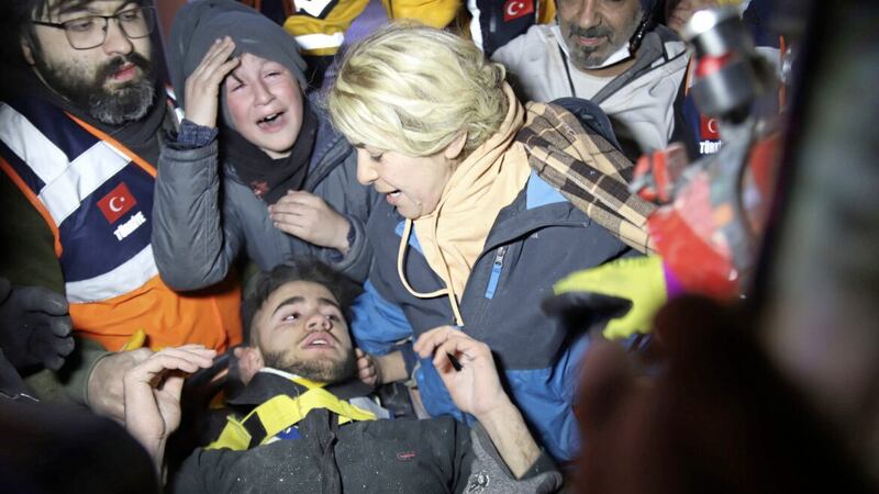 Rescuers and mother surround Adnan Mohammet Korkut after he was rescued in Gaziantep, southern Turkey. The teenager was pulled largely unscathed from beneath the rubble of a collapsed building. Picture by IHA via AP 