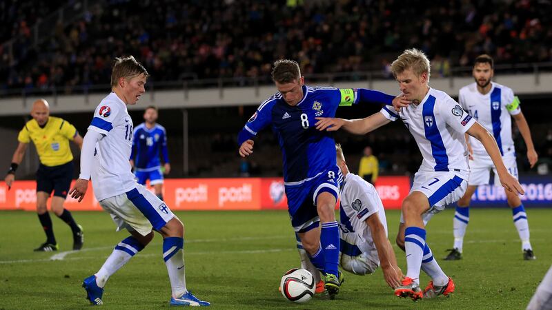 Finland's Juhani Ojala battles for possession with Northern Ireland captain Steven Davis during Sunday's Euro 2016 qualifier at the Olympic Stadium in Helsinki<br />Picture: PA