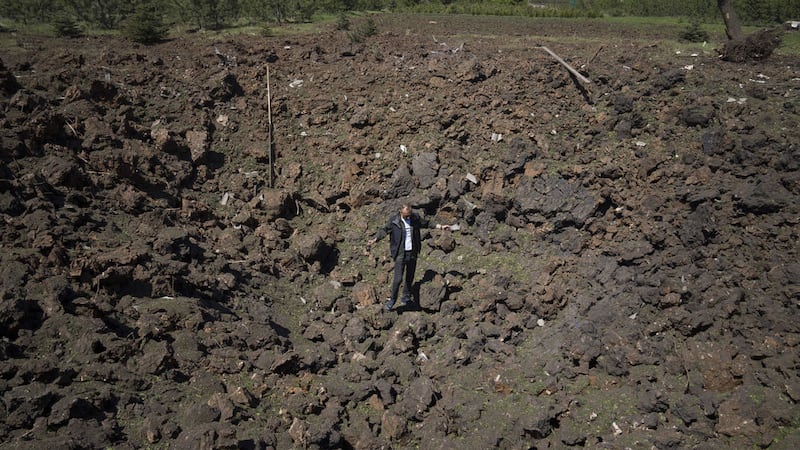 A man stands in a crater of an explosion after Russian airstrike in Bakhmut, Donetsk region, Ukraine, Saturday, May 7, 2022 (AP Photo/Evgeniy Maloletka)&nbsp;