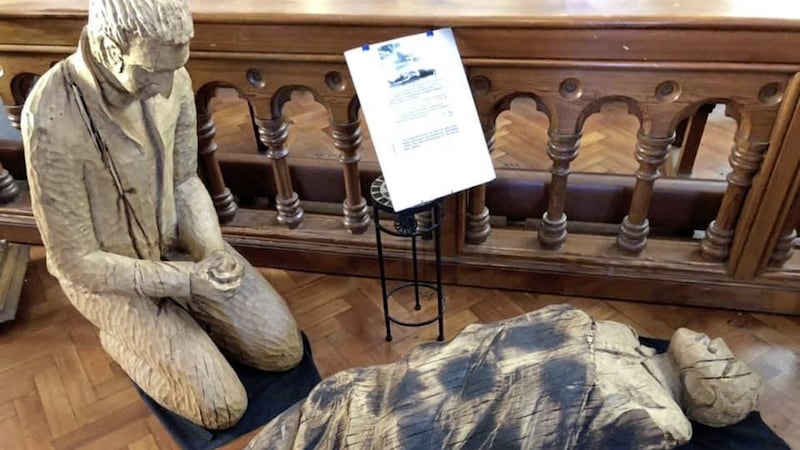 The wooden carving of Fr Alec Reid is inspired by a photograph of him giving the Last Rites to a British soldier in 1988. Picture by Bridget Delaney 