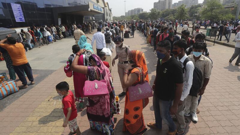 People wearing masks as a precaution against the coronavirus stand in queues to board trains at Lokmanya Tilak Terminus in Mumbai, India (AP Photo/Rafiq Maqbool)&nbsp;
