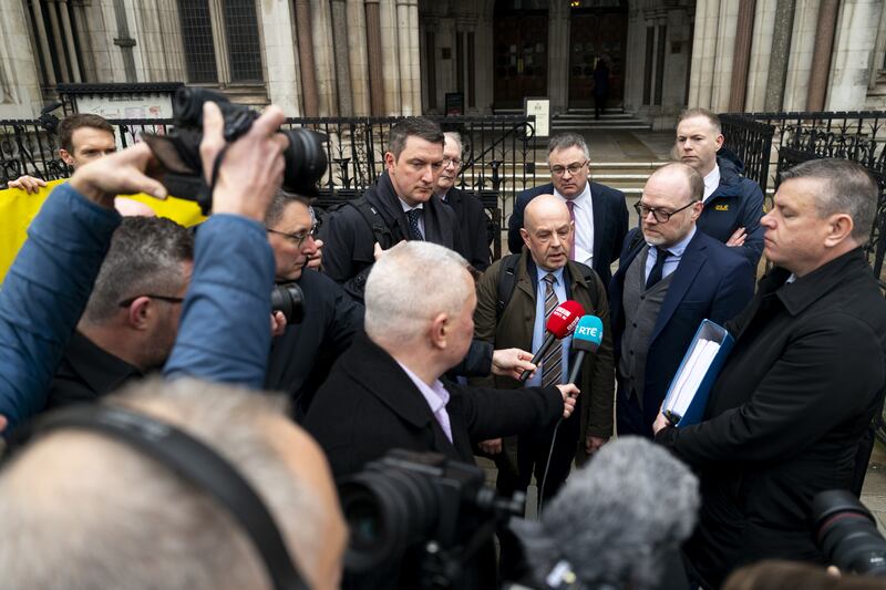 Journalists Barry McCaffrey (centre) and Trevor Birney (centre right) speak to the media outside the Royal Courts of Justice in London