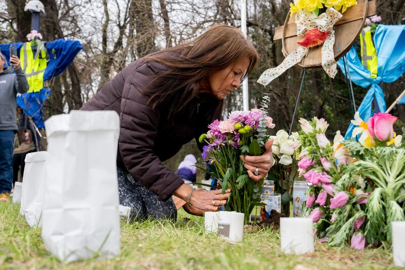Elisa Salcedo lays flowers in front of the memorial site to honour the construction workers who lost their lives (Kaitlin Newman/The Baltimore Banner/AP)