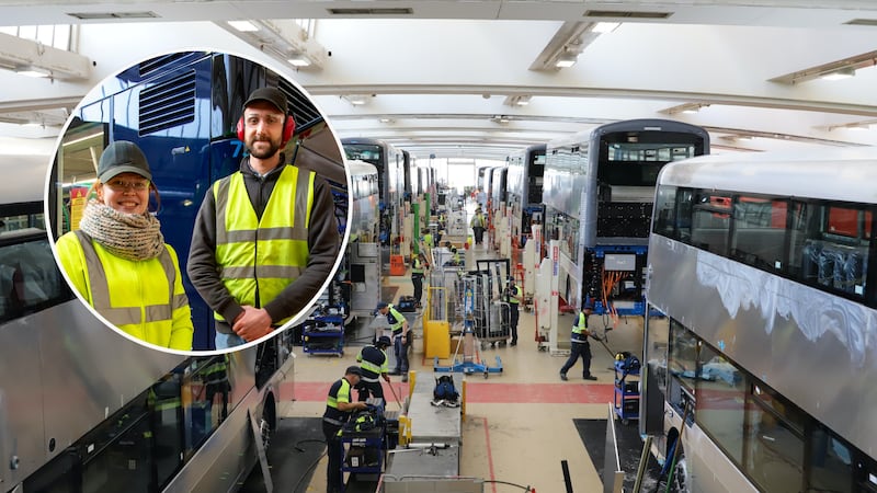 Wide angle view of the Wrightbus factory floor where people work on shells of double-decker buses. There is a circle inset image with two apprentices posing.