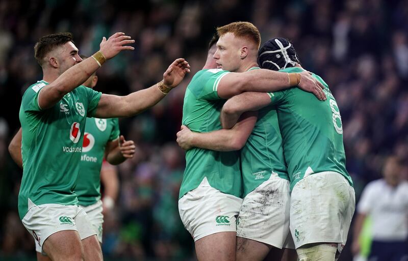 Ciaran Frawley (centre) celebrates with Ireland team-mates after scoring against Wales