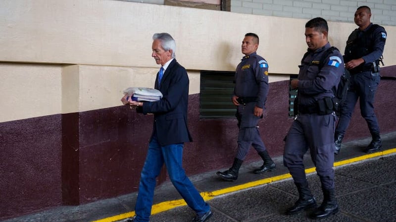 Journalist Jose Ruben Zamora is escorted in handcuffs by police (Moises Castillo/AP)