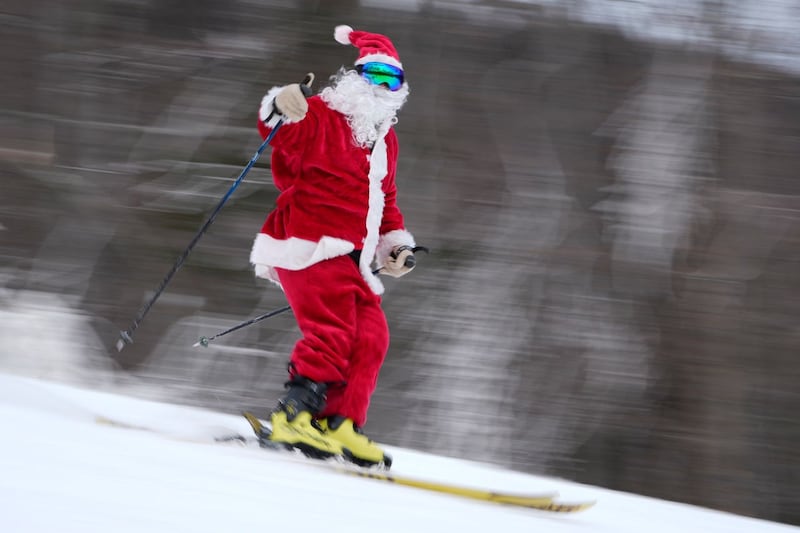 A skier dressed as Santa Claus skis for charity at the Sunday River Ski in Newry, Maine 