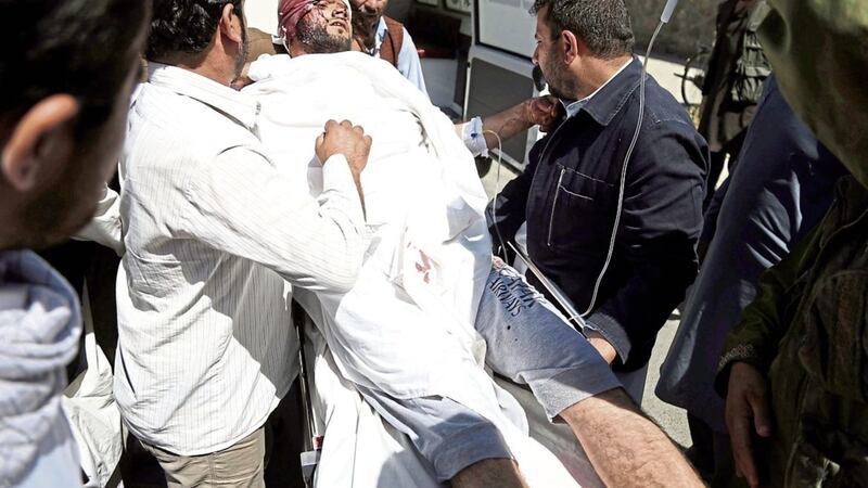 People carry an injured man after a suicide attack in Kabul, Afghanistan PICTURE: Rahmat Gul 