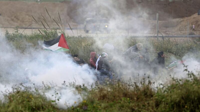 Palestinian protesters run for cover from teargas fired by Israeli troops during a demonstration near the Gaza Strip border with Israel Picture by Khalil Hamra) 