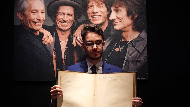 Christie’s books and manuscripts specialist Mark Wiltshire holds a first edition of Gustave Dore and Blanchard Jerrold’s London, A Pilgrimage, inscribed by Sir Mick Jagger (Jonathan Brady/PA)