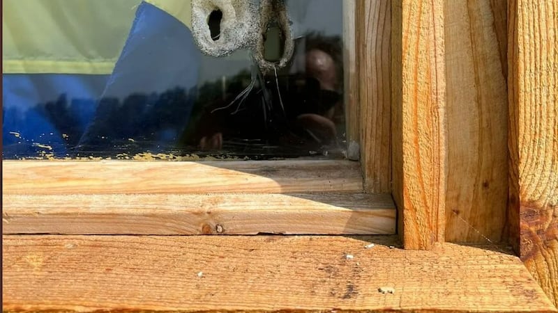 A window with a plastic pane had a hole burned through it with a lighter. Photo: Twitter