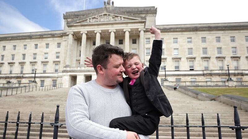 Mairtin Mac Gabhann with his six-year-old son Daithi Mac Gabhann outside the Parliament Buildings in Stormont, ahead of the introduction of Daithi’s Law (Liam McBurney/PA)