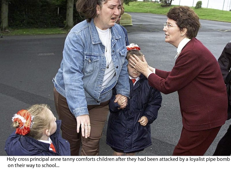 Former Holy Cross principal Anne Tanney&#39;s face was beamed around the world following a loyalist protest outside the girls primary school in 2001. She is pictured comforting a mother and child after they were attacked by a loyalist pipe bomb on their way to school. 