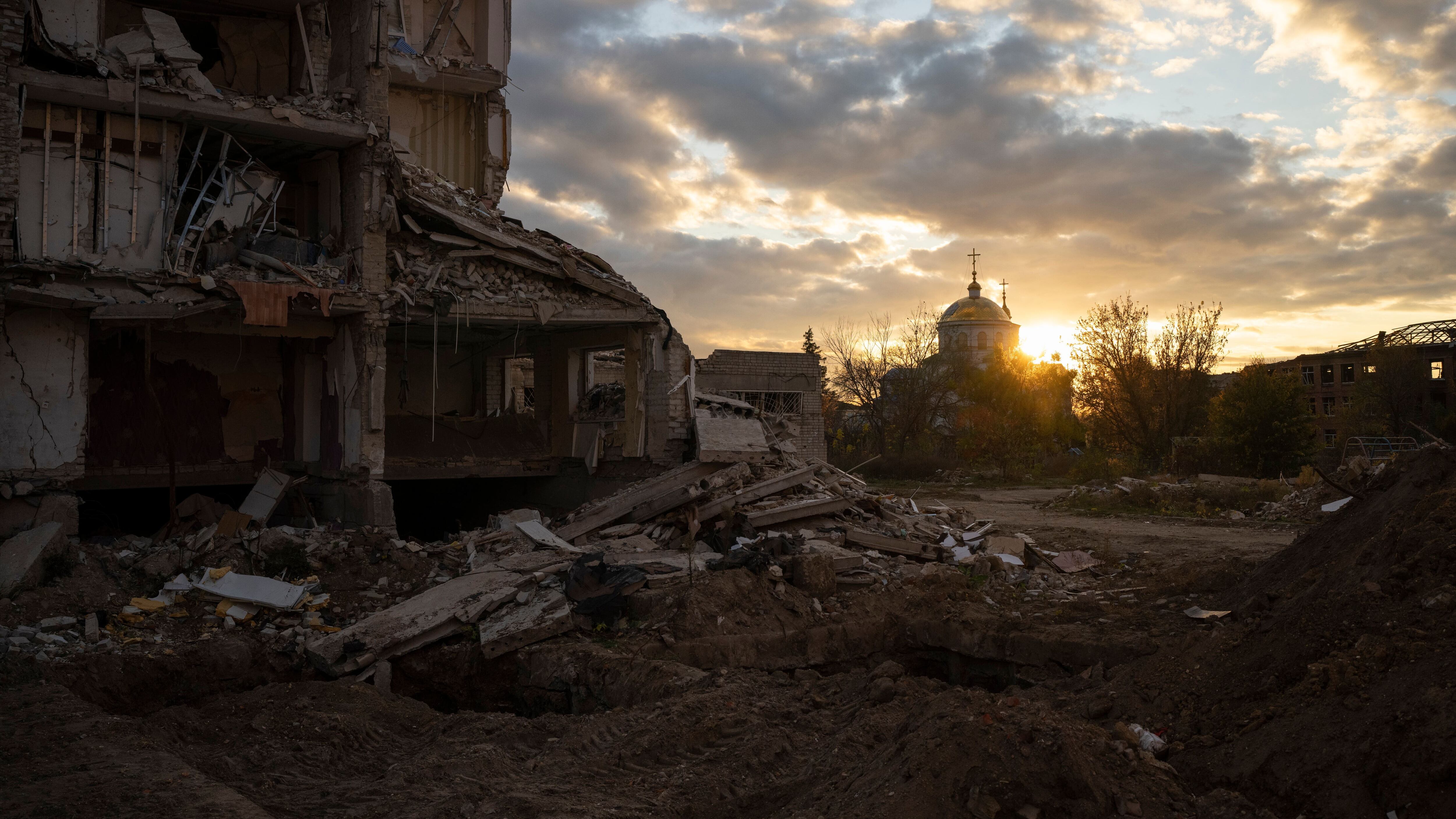 The sun sets over a destroyed building in Izyum, Ukraine (Bram Janssen/AP)