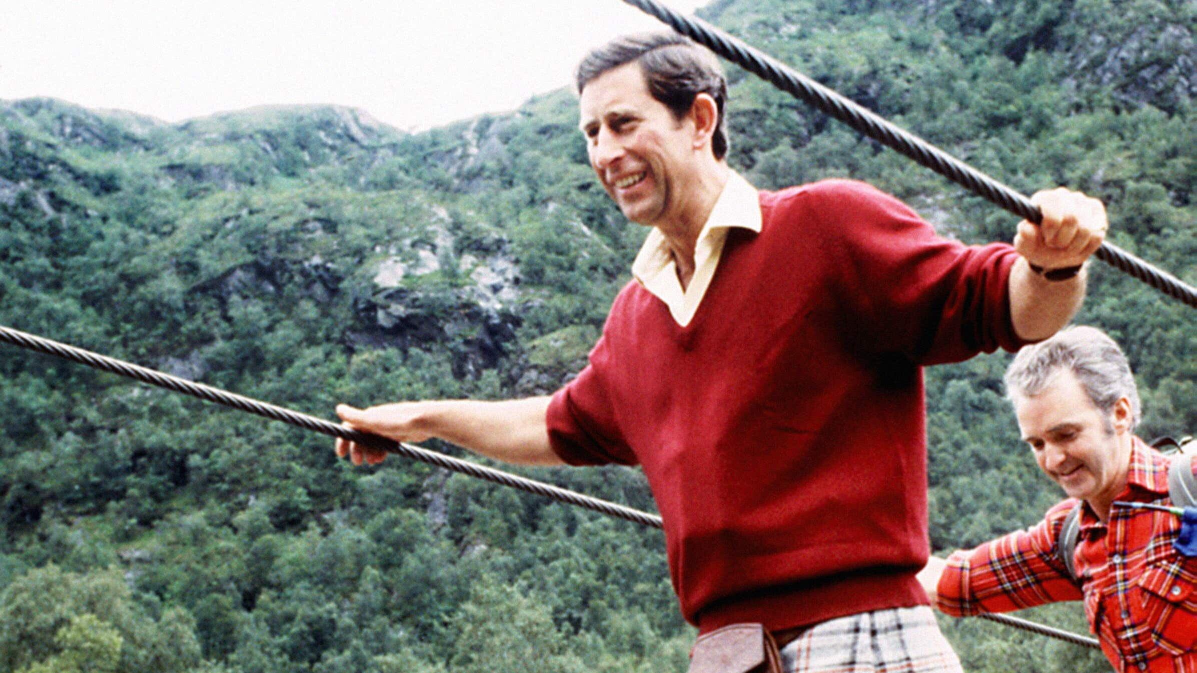 The then-Prince of Wales negotiating a two-inch wide wire bridge during a trek in the foothills of Ben Nevis with the Lochaber Mountain Rescue Team in 1987 (PA)
