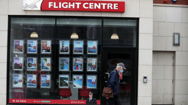 &nbsp;A man passes the window of a travel agent in Dublin's city centre as the Government continues to recommend that all non-essential overseas travel should be avoided during Phase 3 of the lifting of restrictions.