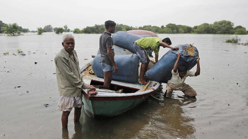 People bring in fodder for their livestock by boat as several areas get flooded in Allahabad, India. Picture by Rajesh Kumar Singh, Associated Press
