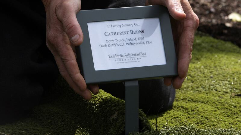 A name plaque is placed on Catherine Burns' grave, after her funeral mass at Clonoe Chapel &nbsp;