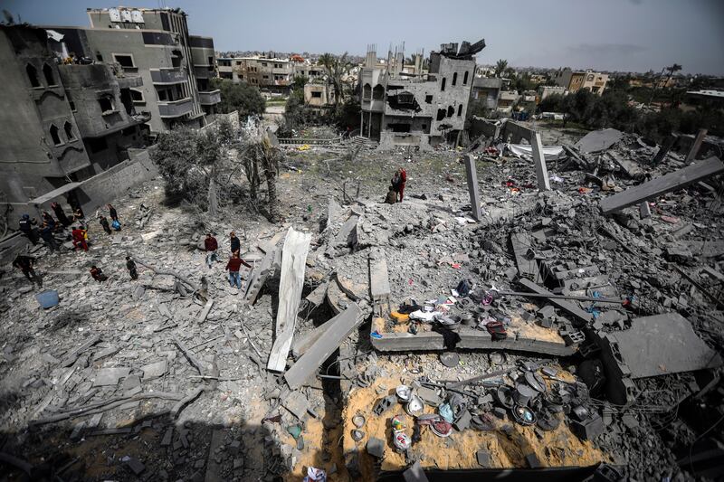 Palestinians inspect the damage to a residential building (Ismael Abu Dayyah/AP)