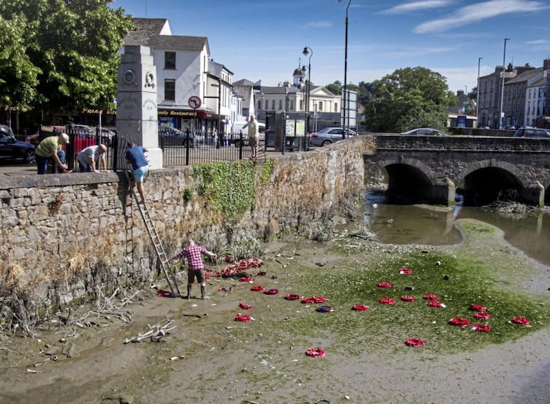 Locals take it upon themselves to  retrieve the wreaths from Clanrye River. Picture by Newraypics.com 