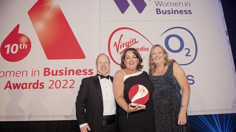 Tina McKenzie (centre) is presented with the 2022 Outstanding Businesswoman of the Year Award from Mike Smith (director of large enterprise and public sector at Virgin Media O2 Business) and Roseann Kelly (chief executive of Women in Business) 