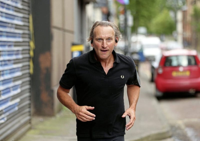 Actor Christopher Eccleston pictured while out jogging in Belfast , visiting Van Morrions childhood home and Cyrus Avenue, George Bests home, and Alex Higgins Picture Mal McCann. 