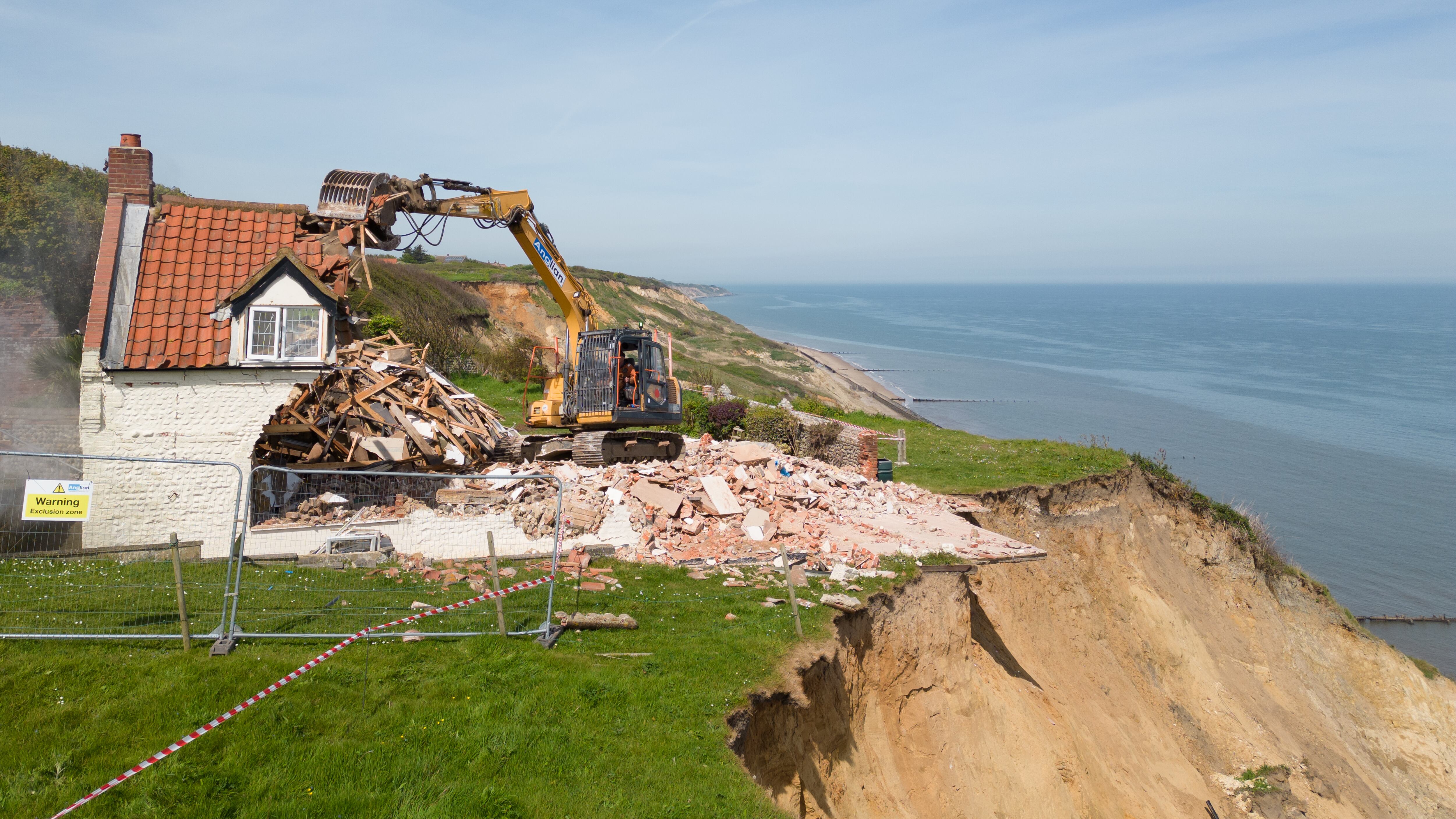 Demolition workers tear down Cliff Farm in Trimingham, Norfolk, which was rendered unsafe to be lived in by the owner after a recent slip left it overhanging the cliff. Picture date: Friday May 10, 2024.