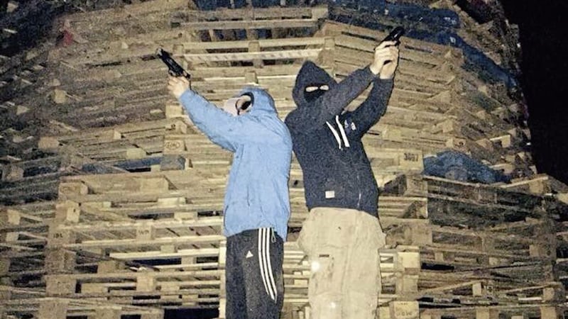 Teenagers posing with guns at the anti-internment bonfire in Beechmount in west Belfast 