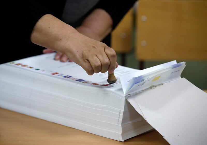 An electoral official stamps the ballots (Boris Grdanoski/AP)