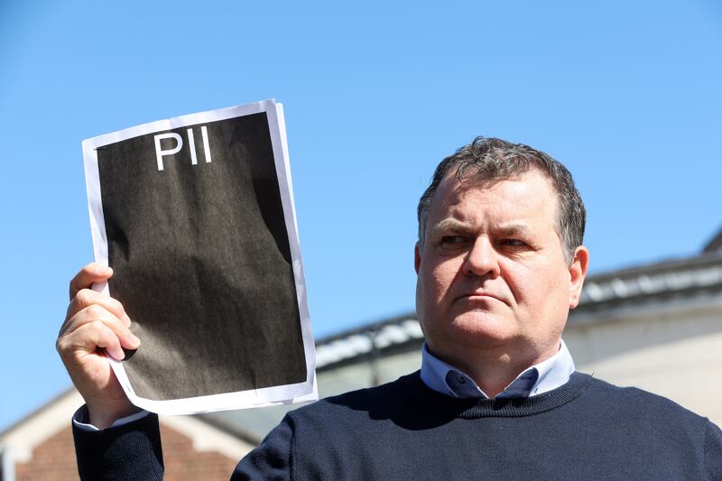 Paddy Fox whose parents Charlie and Tess Fox were murderedin 1992 holds up a Public Interest Immunity (PII) certificate  at Belfast Laganside Court. PICTURE: MAL MCCANN