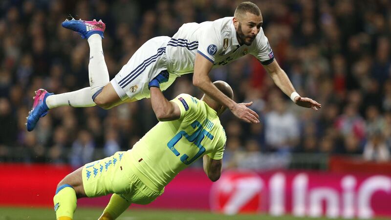 Real Madrid's Karim Benzema clashes with Napoli keeper Pepe Reina at the Bernabeu