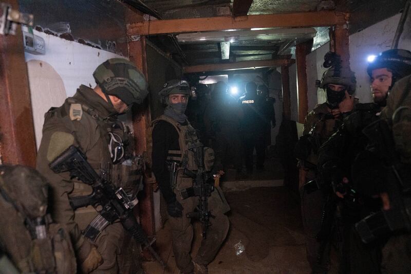 Israeli soldiers stand in a Hamas tunnel underneath a cemetery in Khan Younis (AP Photo/Sam McNeil)