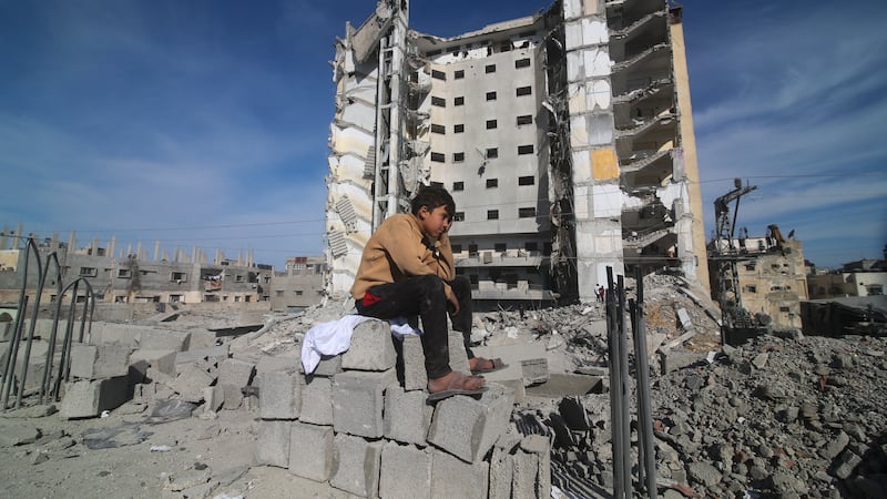 A Palestinian boy sits outside a residential building destroyed in an Israeli strike in Rafah, Gaza Strip (Hatem Ali/AP)