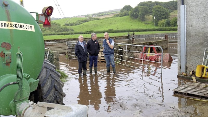 Tyrone farmer Ashley McKelvey shows UFU leaders Ivor Ferguson and Barclay Bell around his flooded farmyard and fields. Picture by Cliff Donaldson 