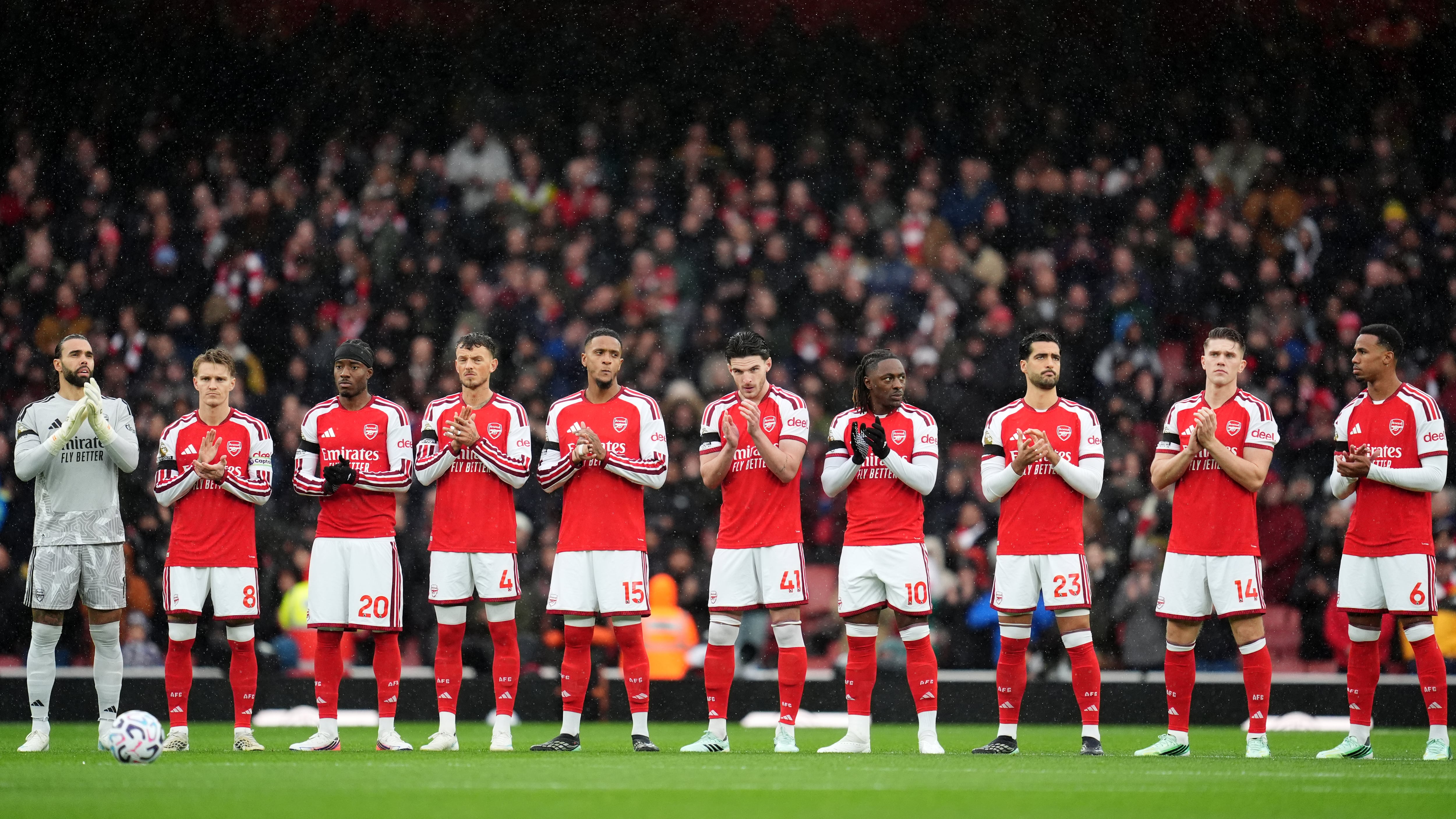 Arsenal players stand for a minute’s applause