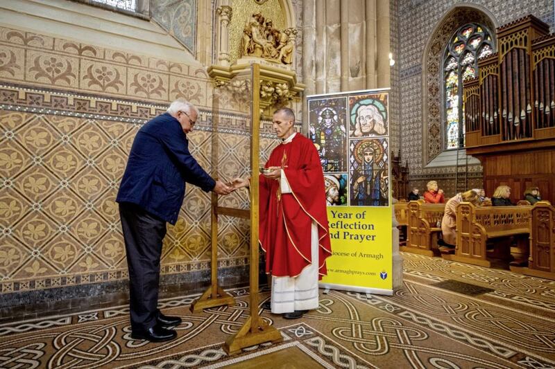 Fr Peter McAnenly, Administrator of the Cathedral parish in Armagh, gives holy communion to a parishioner from behind a screen. Churches have introduced a range of measures to allow public worship to safely resume as coronavirus lockdown measures are relaxed. Picture by Liam McBurney/PA Wire 