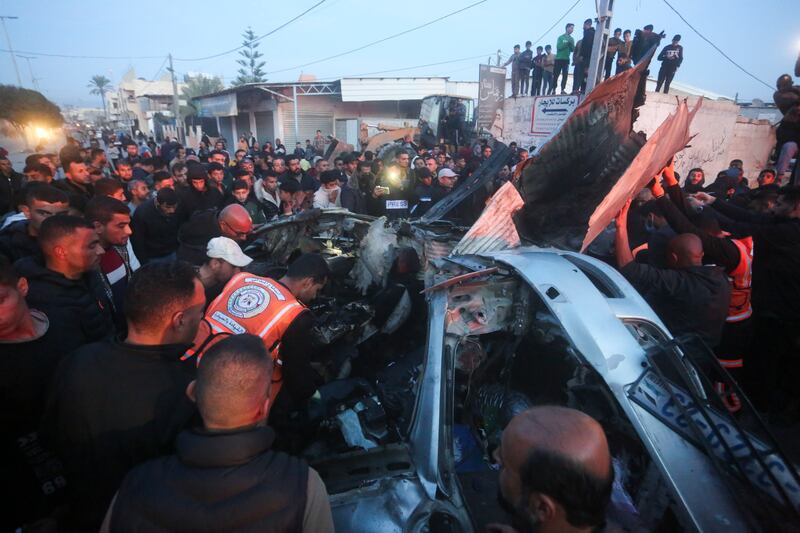 Palestinians surround a car which was hit by an Israeli air strike in Rafah, Gaza Strip (Hatem Ali/AP)