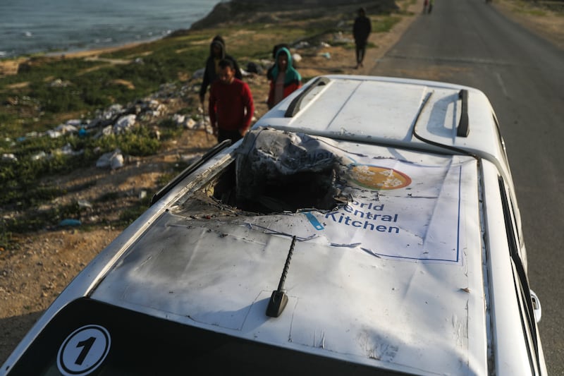 Palestinians inspect a vehicle with the logo of the World Central Kitchen wrecked by an Israeli airstrike (Ismael Abu Dayyah/AP)