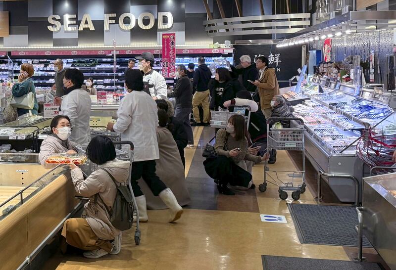 Customers in a supermarket in Toyama react to the earthquake (Kyodo News/AP)