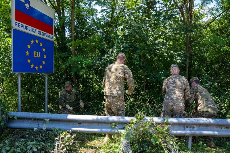 Slovenian soldiers deployed for the removal of a border fence remove razor wire at the border crossing with Croatia in Krmacina, Slovenia, in July 2022