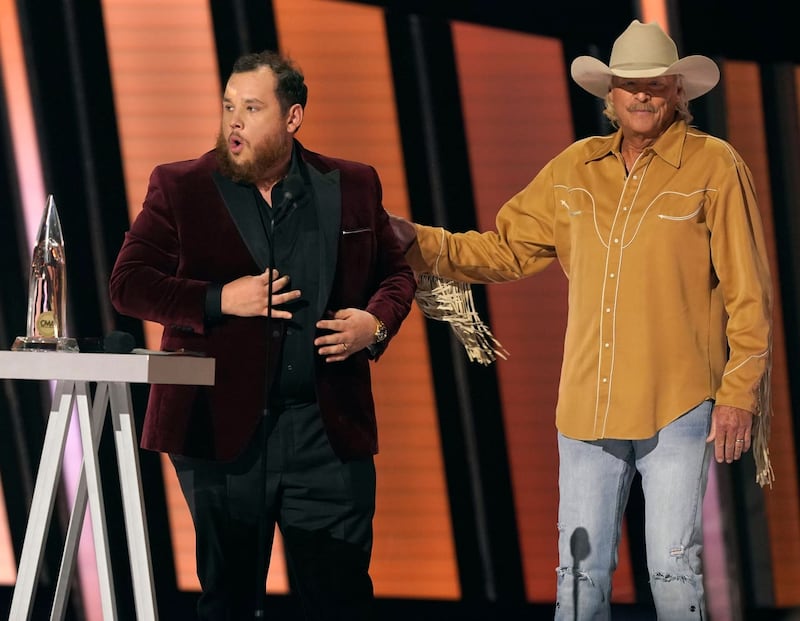 Luke Combs, left, accepts the award for entertainer of the year as presenter Alan Jackson looks on at the 55th annual CMA Awards at the Bridgestone Arena in Nashville, Tennessee