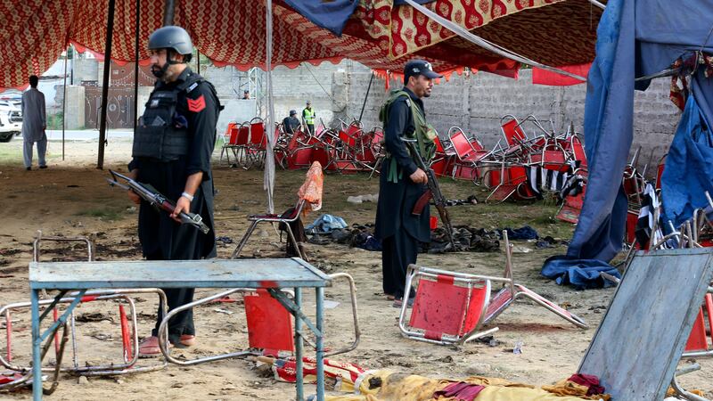 Pakistani police officers stand guard following the suicide bomber attack in the Bajur district of Khyber Pakhtunkhwa (Mohammad Sajjad/AP)